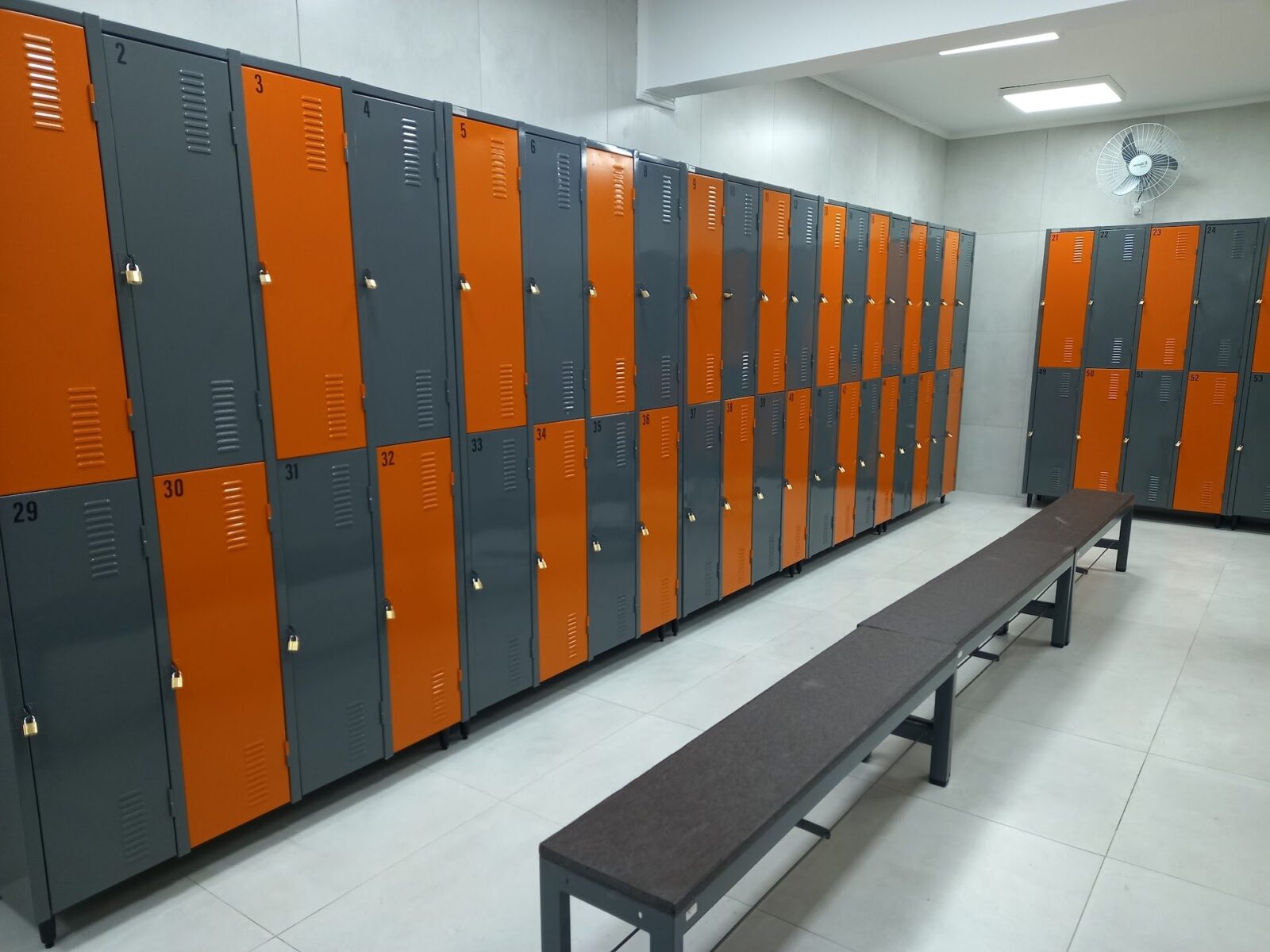 Armários locker de aço em vestiário corporativo com compartimentos individuais.